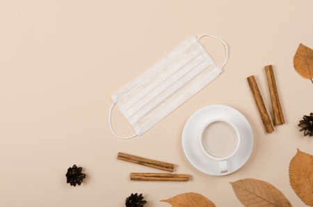 Autumn background with coffee, cinnamon and leaves on light background
