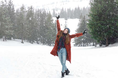 Girl looking on mountain view wearing hat and coat