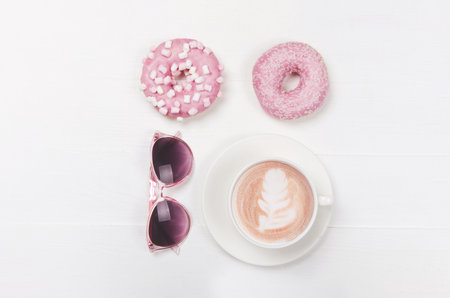 Flat lay composition with donuts and cup of coffee on white backgroundの写真素材