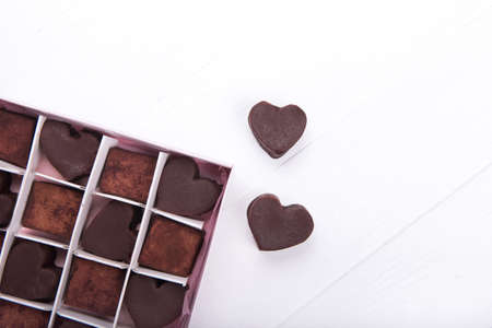 Box with chocolate heart shaped sweets on white background. Valentine Day concept. Copy space.