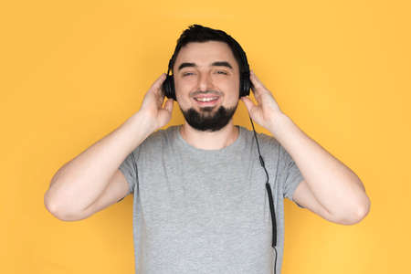 Handsome male with headphones on head listening to the music and smiling.の写真素材