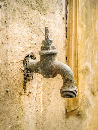 old and broken faucet representing the need to treet natural resources in a sustainable wayの写真素材