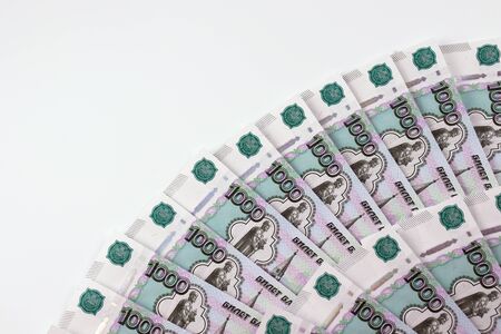 Russian banknotes in denominations of one thousand rubles are on a table in the lower right corner...