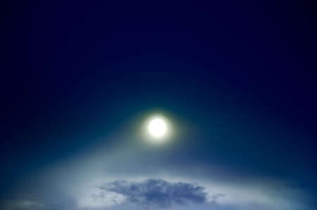 Bright shine through night sky with clouds  Blue tint の写真素材