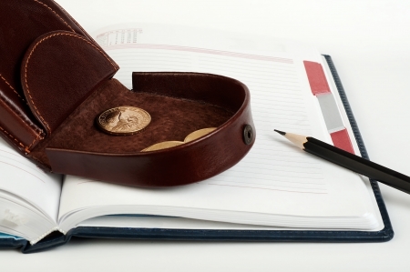 Purse with one dollar coin on the diary and pencilの写真素材