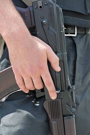 Ukrainian soldier with Kalashnikov rifle. The hand on the machine gun close-up.