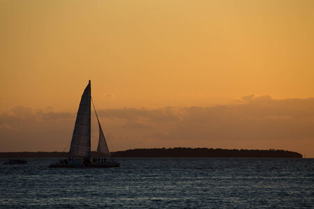 sailing catamaran at sunsetのeditorial素材