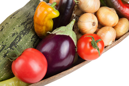 assorted vegetables lying in a wooden scoop isolated on white backgroundの写真素材