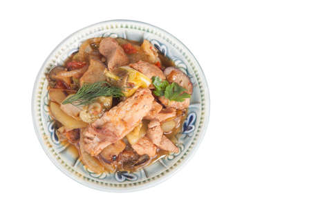 meat stew with vegetables and herbs in a bowl isolated on white backgroundの写真素材