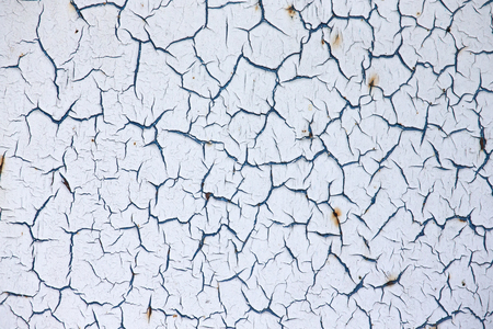 Close-up detail of cracked paint on rusty metal wall.の写真素材