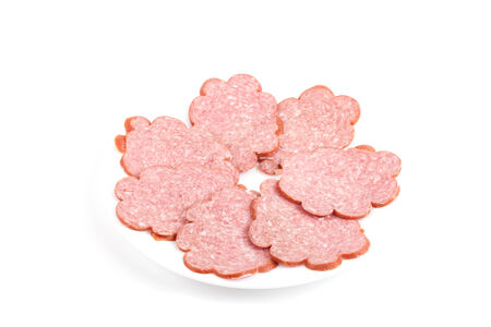 sliced ââsausage on a white plate isolated on white backgroundの写真素材