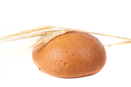 loaf of black bread with ears of rye isolated on white backgroundの写真素材