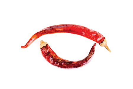 Two sharp bright red dried peppers isolated on white backgroundの写真素材