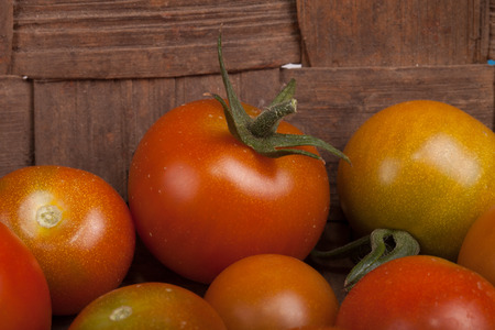 freshly picked tomatoes in old dirty wooden basketの写真素材
