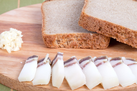black bread, bacon, garlic on the board. Shallow depth of fieldの写真素材