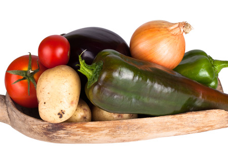 assorted vegetables lying in a wooden scoop isolated on white backgroundの写真素材