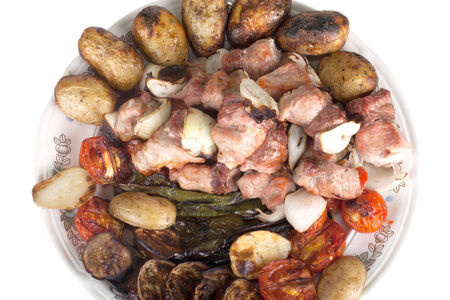 shish kebab and grilled vegetables on a plate isolated on white backgroundの写真素材