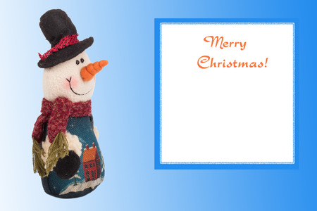 knitted snowman with a card on a background of blue Christmasの写真素材