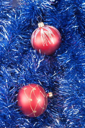 Red Christmas balls on the background of blue tinselの写真素材
