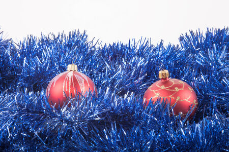 Red Christmas balls on the background of blue tinselの写真素材