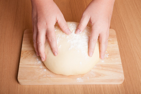 Dough on a board with your handsの写真素材