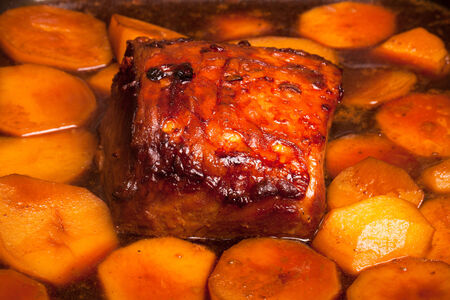piece of pork and potatoes in the pan for roastingの写真素材