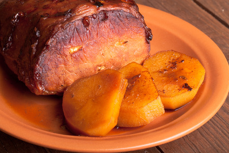 piece of pork, peppers and potatoes in an old wooden tableの写真素材