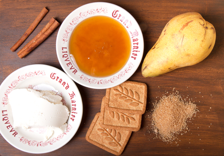 Honey, cinnamon, pear, brown sugar, ricotta cheese and cookies on a wooden boardの写真素材