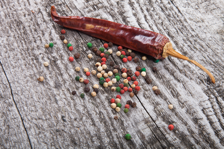 different varieties of peppers on old wooden boardの写真素材