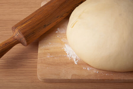 dough on a board and rolling pin with flour dusting. Close-upの写真素材