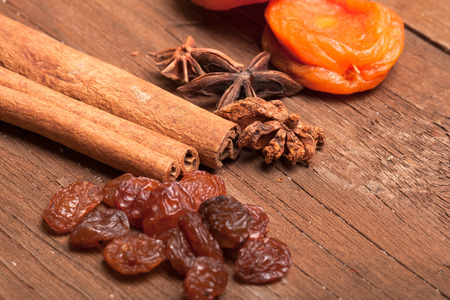 Raisins, cinnamon, anise and dried apricots lying on an old wooden table. small depth of fieldの写真素材