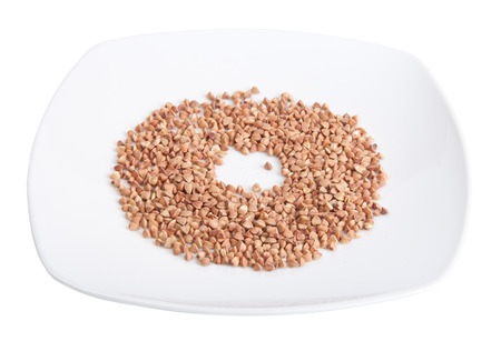 plate with buckwheat groats isolated on white backgroundの写真素材