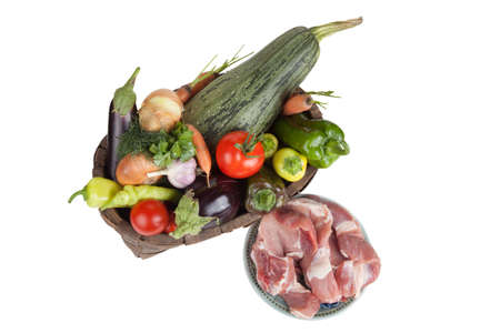 Vegetables in old wooden basket and fresh meat isolated on white backgroundの写真素材
