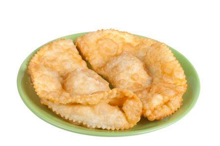 cheburek stuffed on a green plate isolated on white backgroundの写真素材