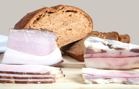 Bread and bacon on a wooden boardの写真素材
