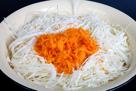 Harvesting of sauerkraut. shredded cabbage and carrots in an old enameled bowl.の写真素材