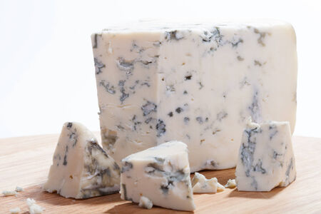 Blue cheese with slices on wooden board. Shallow depth of fieldの写真素材