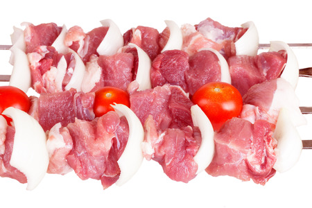 Fresh meat with onion and tomato on a skewer isolated on white backgroundの写真素材