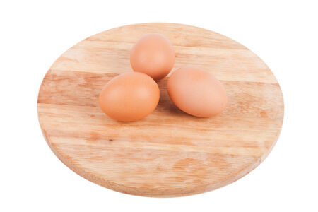 Three eggs on a wooden board isolated on white backgroundの写真素材