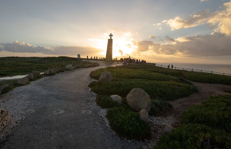tourists watching the sunset near the cross monument at Cabo da Roca, the western point of Europe - Portugalの写真素材