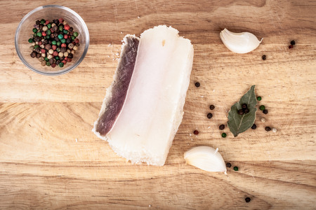 raw bacon with spices on wooden tableの写真素材