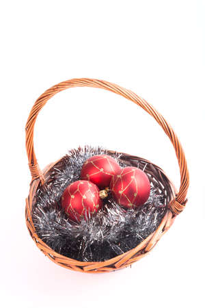Christmas balls in a wicker basket on a tinselの写真素材