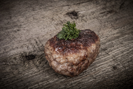 cutlet with parsley leaves on old wooden table.の写真素材