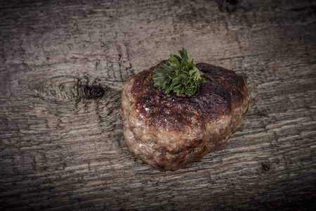 cutlet with parsley leaves on old wooden tableの写真素材