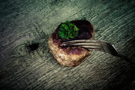 cutlet and slice on a fork on old wooden table.Tintedの写真素材