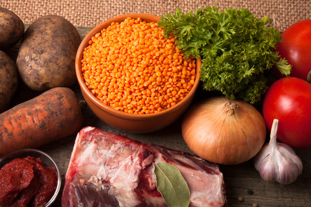 Ingredients for Turkey vegetable soup with red lentils, lying on an old wooden board and sacking.の写真素材