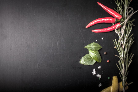 Herbs and spices. basil, red pepper, salt and rosemary on a black background. With space for textの写真素材