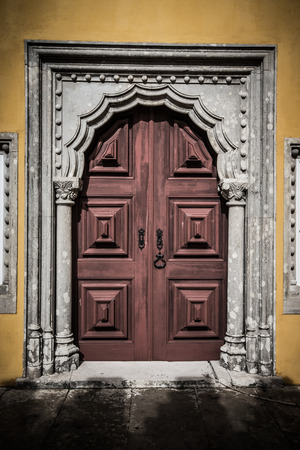 old wooden door framed by a carved stone. tintedの写真素材