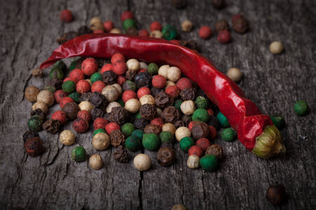 red hot chili peppers and peppercorns on an old wooden tableの写真素材