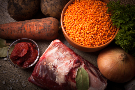 Ingredients for Turkey vegetable soup with red lentils, lying on an old wooden board and sacking.の写真素材